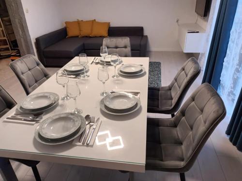 uma mesa com pratos e copos de vinho em Apartment Povljana 224b em Povljana