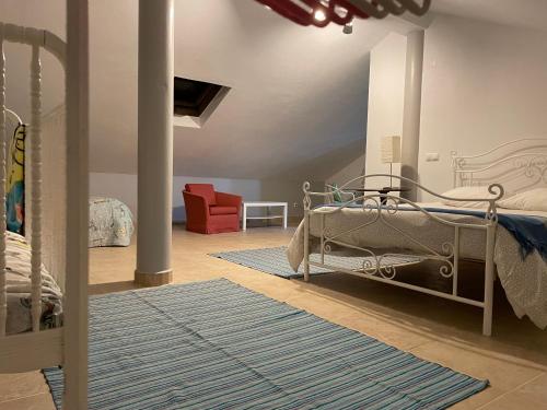 1 dormitorio con 1 cama y 1 silla roja en À Descoberta d'Angra!, en Angra do Heroísmo