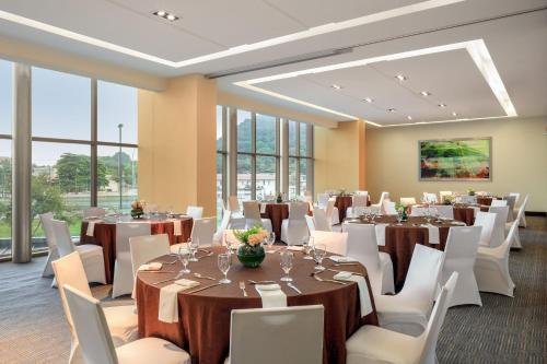 a banquet room with tables and white chairs and windows at Marriott Panama Hotel - Albrook in Panama City