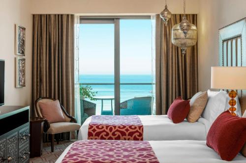 a hotel room with a bed and a view of the ocean at Ajman Saray, a Luxury Collection Resort, Ajman in Ajman 