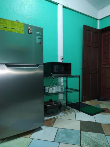 a kitchen with a stainless steel refrigerator and a table at Villa Gabriela, Casa Tucan in Liberia