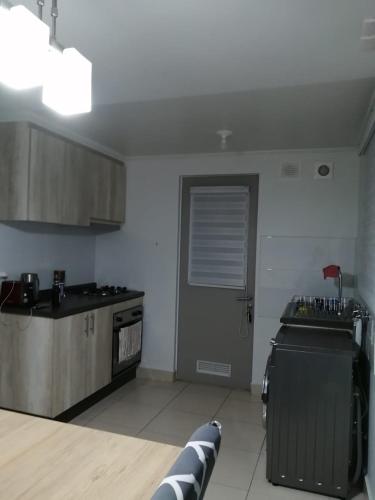 uma cozinha com um fogão e uma porta num quarto em Habitación Bosquemar em Puerto Montt