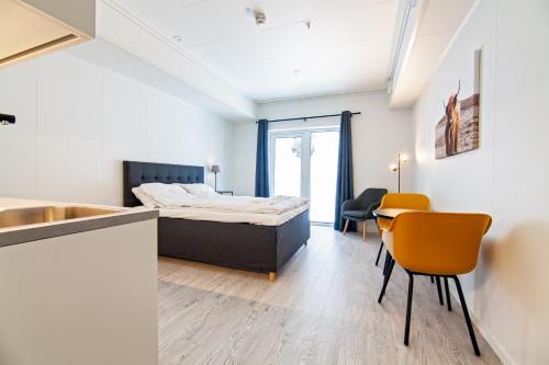 1 dormitorio con 1 cama, mesa y sillas en Stylish and serviced Studio apartment in Lofoten en Svolvær