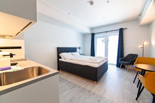 1 dormitorio con 1 cama, lavamanos y mesa en Stylish and serviced Studio apartment in Lofoten en Svolvær