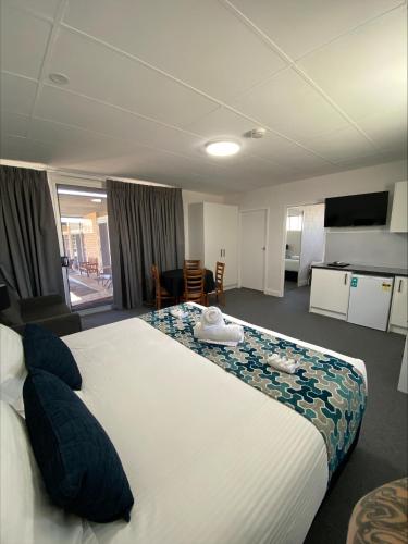 a hotel room with a large bed with blue pillows at Hilltop Motel in Broken Hill