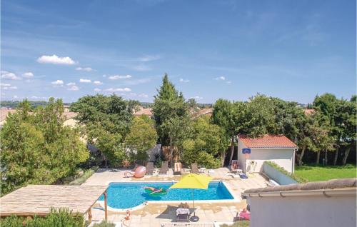 une piscine extérieure avec un parasol jaune dans l'établissement Beautiful Home In Thézan-Lès-Béziers, à Thèzan-lès-Béziers
