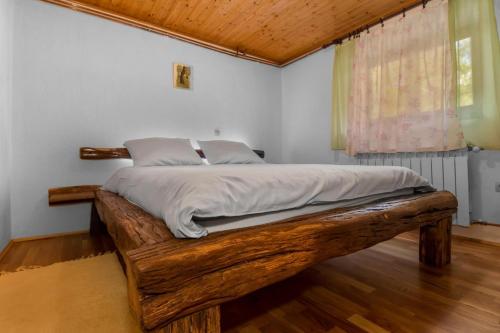 a bedroom with a wooden bed in a room at Holiday house with a swimming pool Breze, Novi Vinodolski - 20493 in Novi Vinodolski