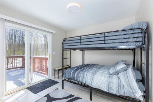 Roscommon的住宿－*4BR 2BA N Shore Hidden Retreat*，一间带双层床的卧室和一个阳台