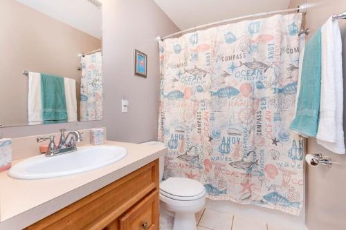 a bathroom with a sink and a toilet and a shower curtain at *4BR 2BA N Shore Hidden Retreat* in Roscommon