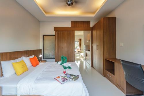 1 dormitorio con 1 cama blanca grande y escritorio en Happy Eight Resort SHA, en Nai Harn Beach