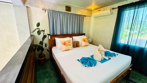 a bedroom with two beds with blue sheets and a window at Hidden of Cailan Inn in El Nido