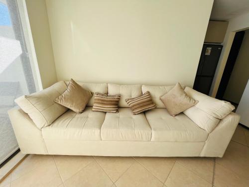 a white couch with pillows on it in a room at Departamento vista al mar 3 habitaciones 2 baños in Constitución