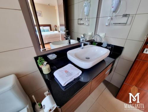 a bathroom with a sink and a mirror at Margarita Apartamentos in Cochabamba