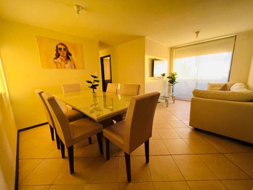 a dining room with a table and chairs and a couch at Departamento vista al mar 3 habitaciones 2 baños in Constitución