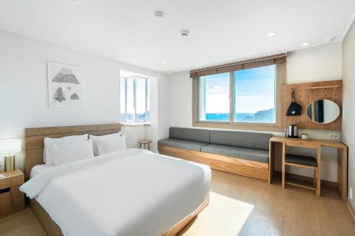 1 dormitorio con 1 cama y 1 sofá en Heyy Seogwipo Hotel en Seogwipo