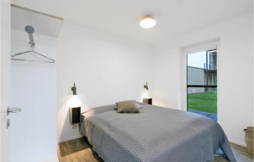 ein weißes Schlafzimmer mit einem Bett und einem Fenster in der Unterkunft Nice Apartment In Lembruch-dmmer See With Kitchen in Lembruch