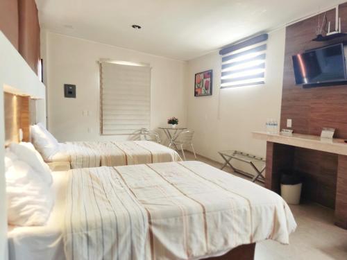 a hotel room with two beds and a fireplace at Casa Paraíso Habitaciones en el Centro de Ciudad Valles in Ciudad Valles