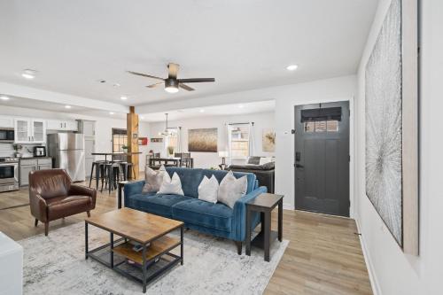 a living room with a blue couch and a table at The Gated Modern Home Near NRG and Medical Center in Houston