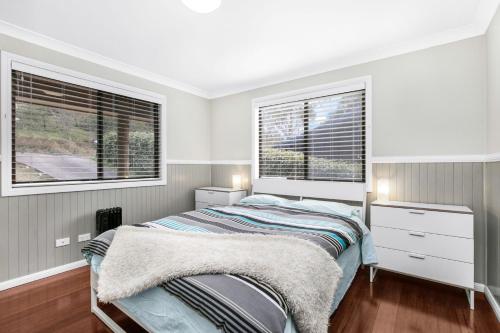 盧拉的住宿－Baileys Retreat，一间卧室设有一张床和两个窗户。