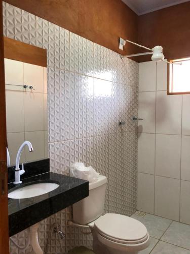 a bathroom with a toilet and a sink and a shower at Recanto do Vale in Pirenópolis