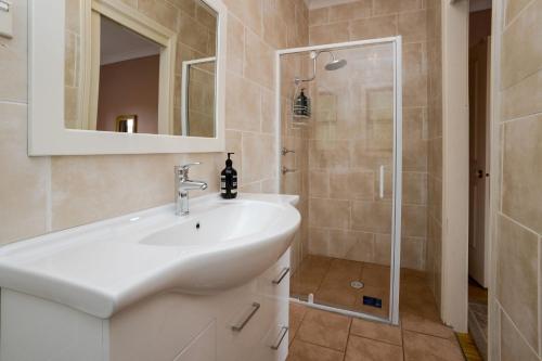 ein Bad mit einem Waschbecken und einer Dusche in der Unterkunft Scenic Cottage in Katoomba