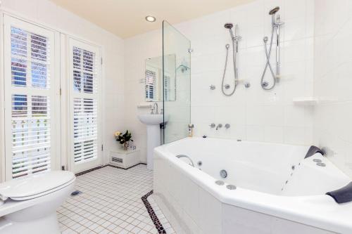 ein weißes Badezimmer mit Badewanne und Toilette in der Unterkunft Bluebell Cottage in Katoomba