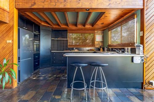 a kitchen with a large counter with stools in it at Grey Gum Lodge in Woodford