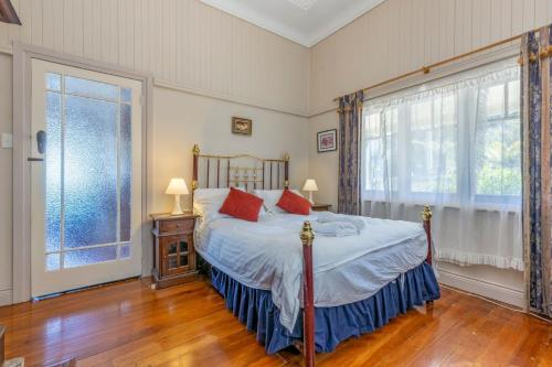 a bedroom with a bed and a large window at Keira Cottage in Katoomba