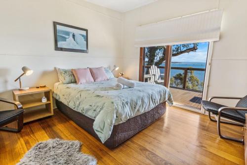 a bedroom with a bed with a view of the ocean at Lakescapes Cottage in Metung