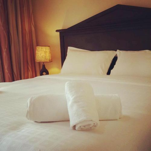 a hotel room with a bed with two towels on it at Nile Village Hotel & Spa in Jinja