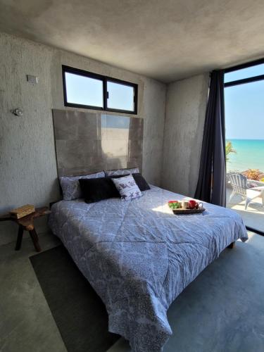 a bedroom with a bed with a view of the ocean at Puerto del Cielo in Chuburná