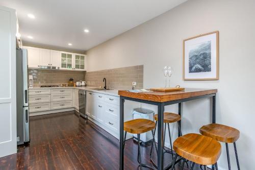 a kitchen with a counter and stools in it at Edelweiss Leura in Leura