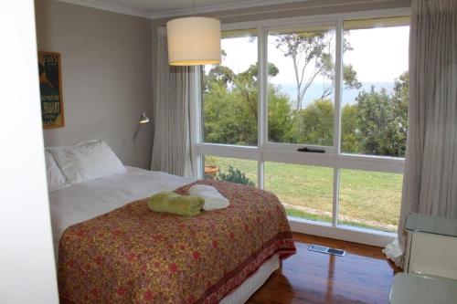 a bedroom with a bed and a large window at Highview in Leura