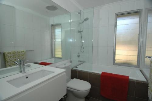a white bathroom with a toilet and a sink at Highview in Leura