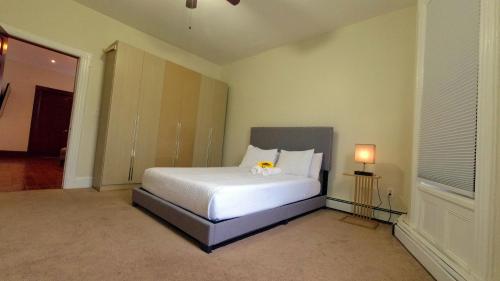 a bedroom with a white bed with a yellow flower on it at El Edén in Parkchester