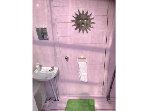 baño con lavabo y pared rosa en GUEST HOUSE SUMIRE - Vacation STAY 34298v, en Nago