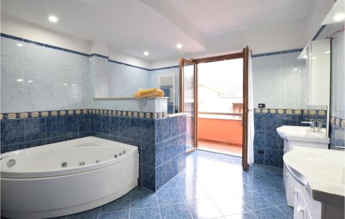 een blauw betegelde badkamer met een bad en een wastafel bij 2 Bedroom Nice Apartment In Omegna in Omegna