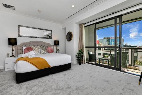 1 dormitorio con cama y ventana grande en Your Family Getaway - Rooftop Spa & Pool!, en Auckland