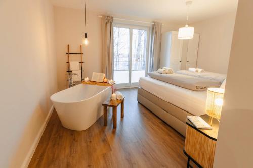 a bathroom with a bath tub and a bed at Frünn Stuuv in Ratzeburg