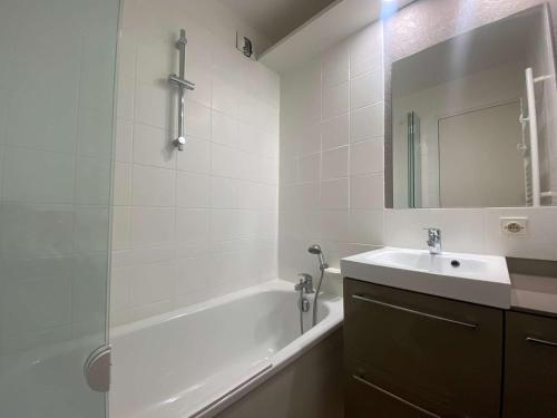 une salle de bain avec une baignoire, un lavabo et un miroir dans l'établissement Appartement 2 pièces avec terrasse, parking, piscines - à 300m de la plage à La Baule - FR-1-245-18, à La Baule