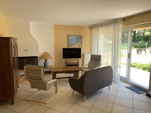 un salon avec une table, des chaises et une télévision dans l'établissement Maison 3 piéces, 80m² à Belz, proche Ria d'Etel - Plages à 4km, jardin fermé, idéal pour 4 pers - FR-1-397-52, à Belz