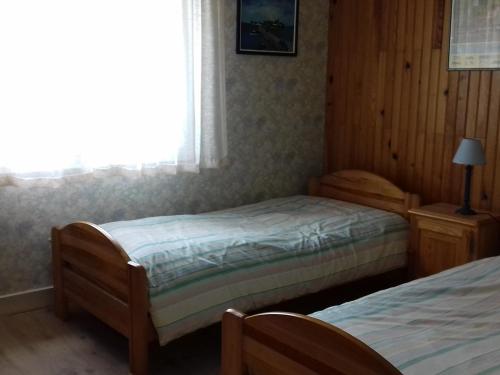 une chambre avec deux lits et une fenêtre dans l'établissement Maison 3 piéces, 80m² à Belz, proche Ria d'Etel - Plages à 4km, jardin fermé, idéal pour 4 pers - FR-1-397-52, à Belz