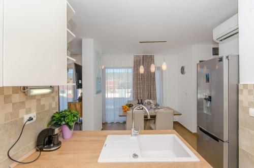 a kitchen with a sink and a stainless steel refrigerator at Apartments Villa LA in Drvenik Veli