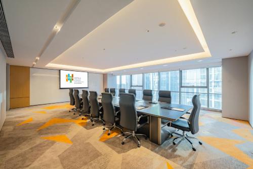 a conference room with a long table and chairs at EVEN Suzhou Grand Canal by IHG in Suzhou