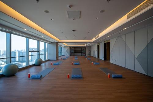 a large room with blue pilates mats on the floor at EVEN Suzhou Grand Canal by IHG in Suzhou