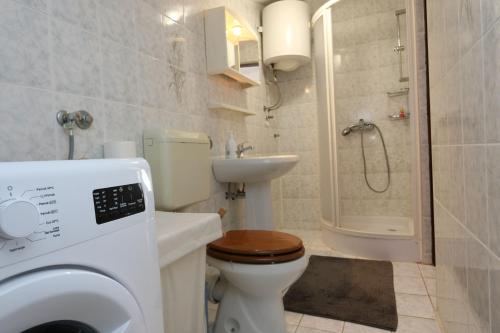 een badkamer met een toilet, een wastafel en een douche bij Apartment Lidija in Šilo