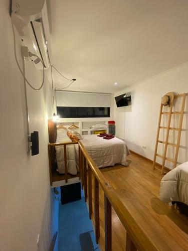 Un dormitorio con una cama y suelo de madera. en Belgrano 360, en Tandil