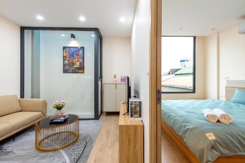 a bedroom with a bed and a couch and a table at Muse Hanoi Boutique Apartment in Hanoi