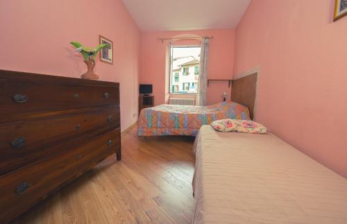 a bedroom with two beds and a dresser and a window at Relax Brugnato in Brugnato