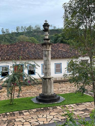 a statue in front of a house with a building at Pousada Condado Santa Maria in Baependi